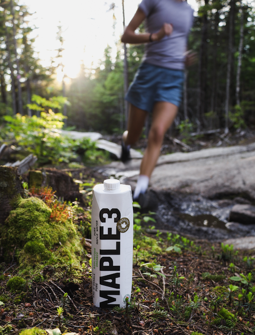 Maple 3 water format 1 L dans la forêt avec une coureuse en arrière plan