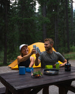 A couple sharing a great moment in nature camping and drinking organic maple water.