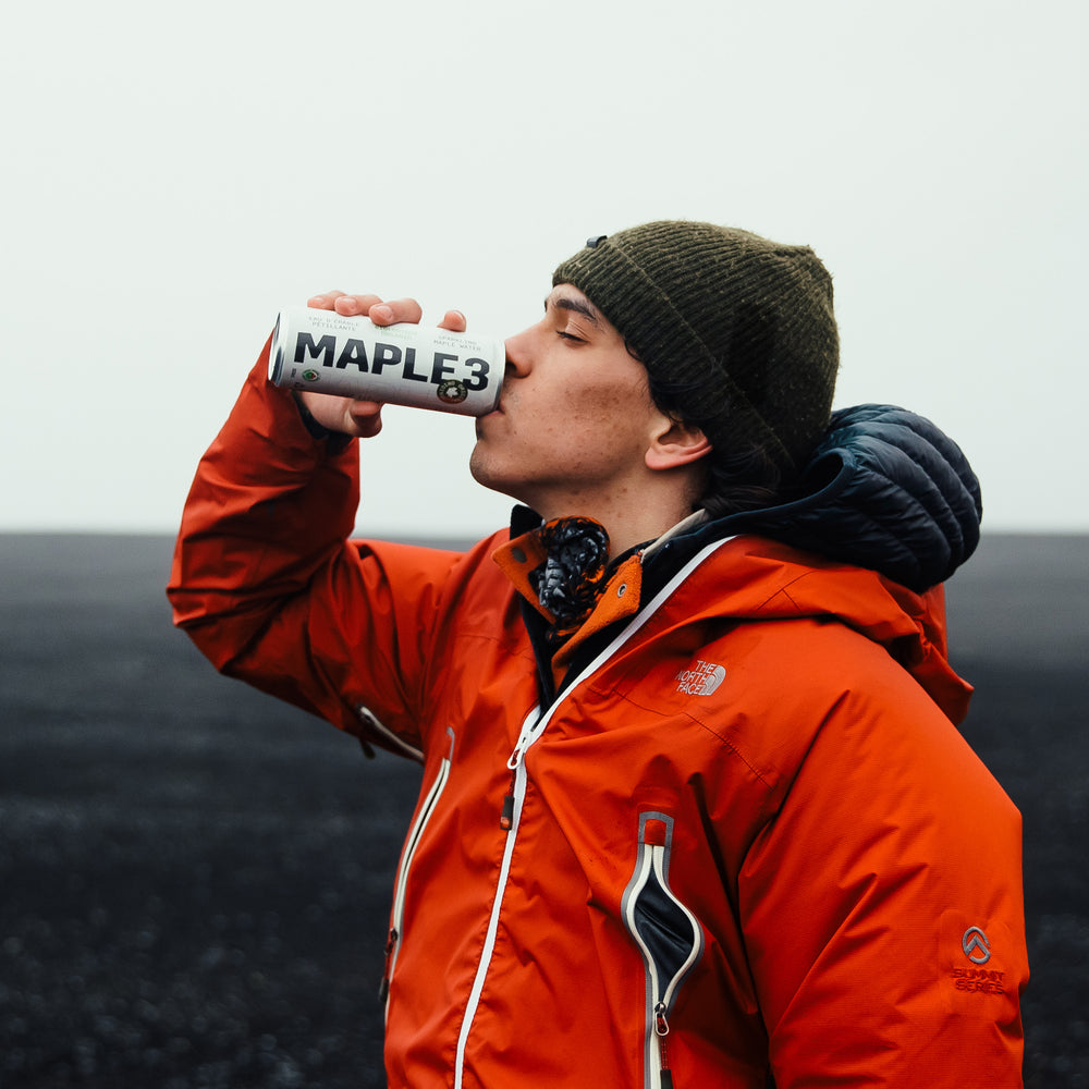 A man drinking a healthy soda beverage after a hike.